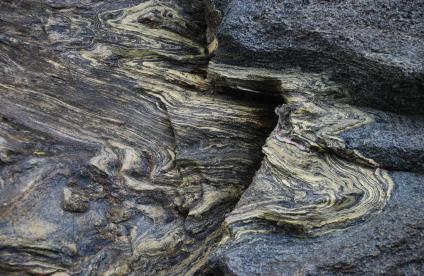 Schistes plissés sur lesquels on observe bien la glaucophane bleue et l’épidote jaune verdâtre (Côte sud de l’Ile de Groix, Morbihan, France, 2007). 